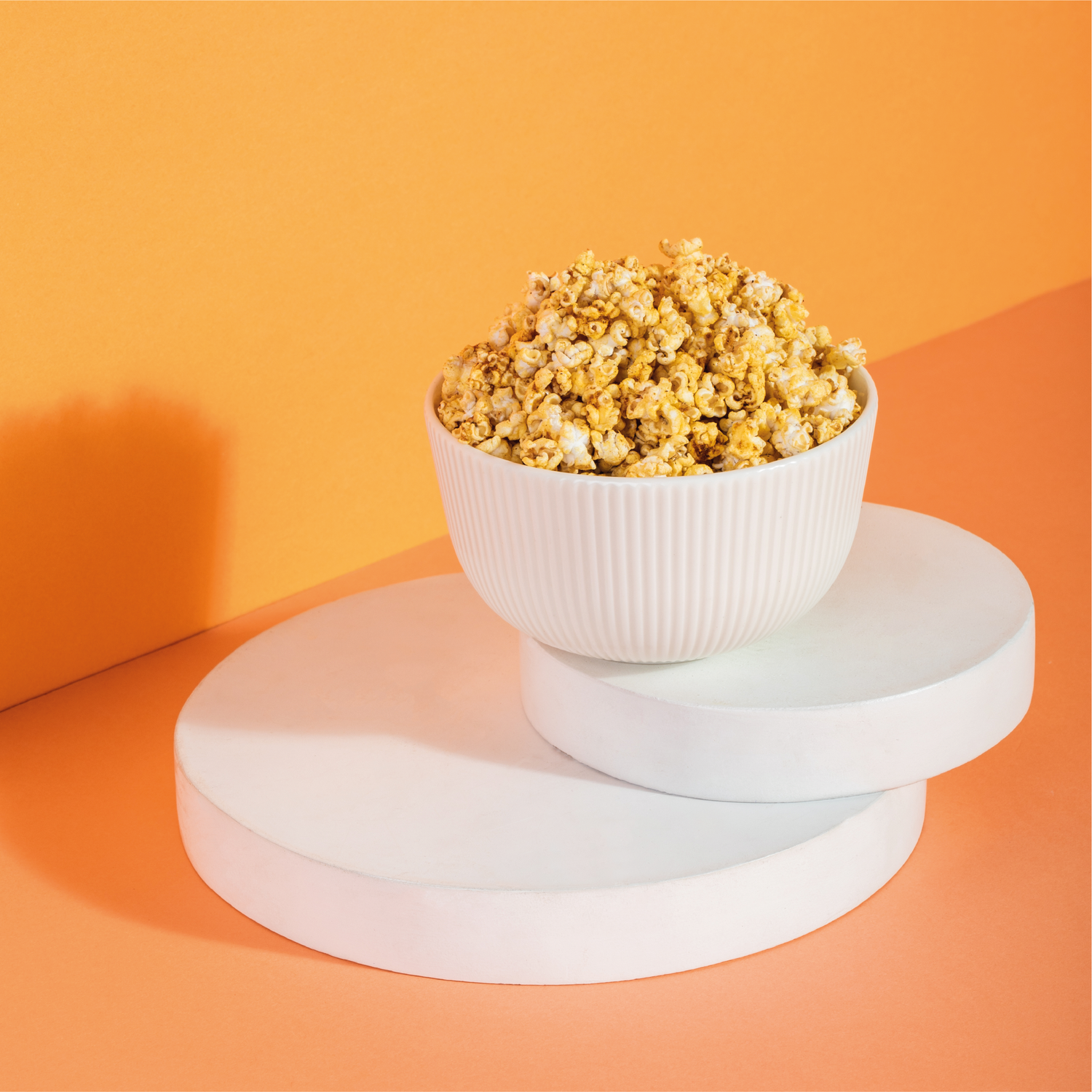 Barbeque Jowar Pops placed in a bowl on top of 2 circular white pieces.