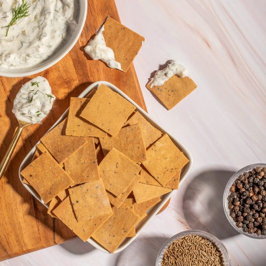 Artisan cumin crackers in a rustic wooden bowl, perfect for a healthy snack, photographed in an appealing square format.